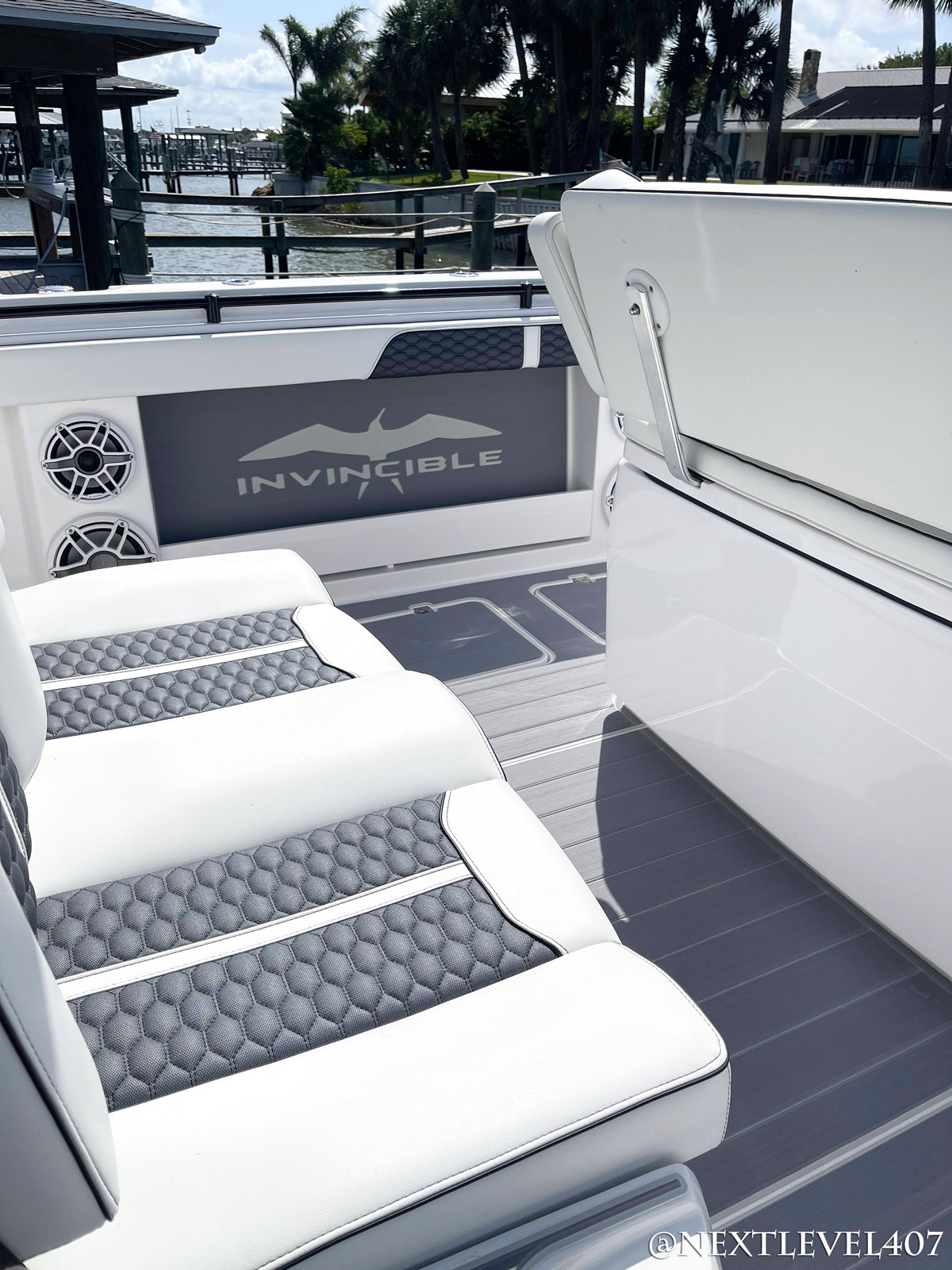 https://floridamarinecustoms.com/wp-content/uploads/2022/01/AFTER-Blue-Invincible-Boat-Custom-SeaDek-Marine-Flooring-Pad-Upgraded-Speakers-Close-Up-Custom-Logo-Pad-On-Water-Leather-Upholstery-Seats-Grey-Center-Console-Fishing-Pole-Holder.jpg